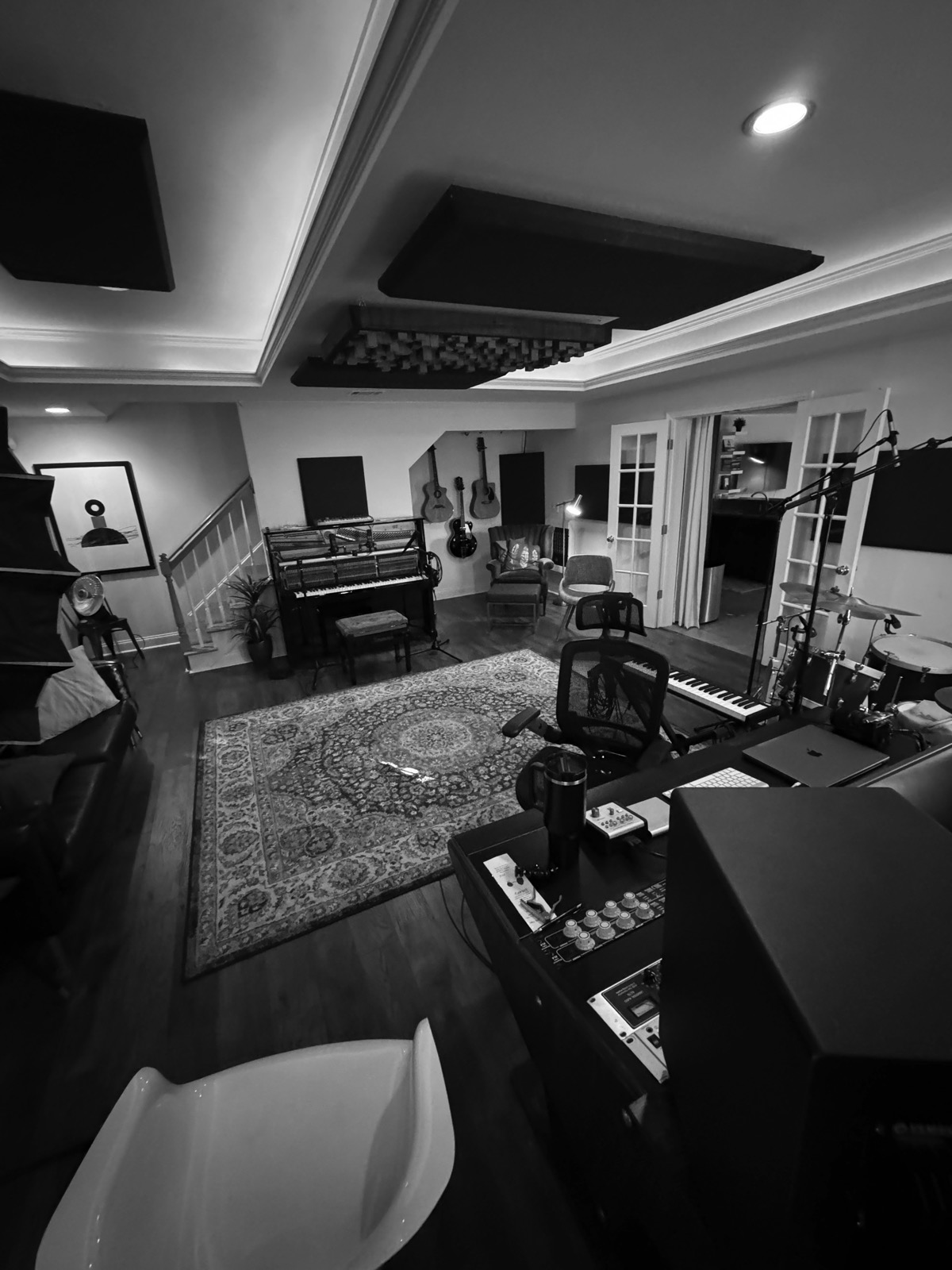 The Curate House studio: a piano, guitars on the wall, a drum kit, and the mixing desk
